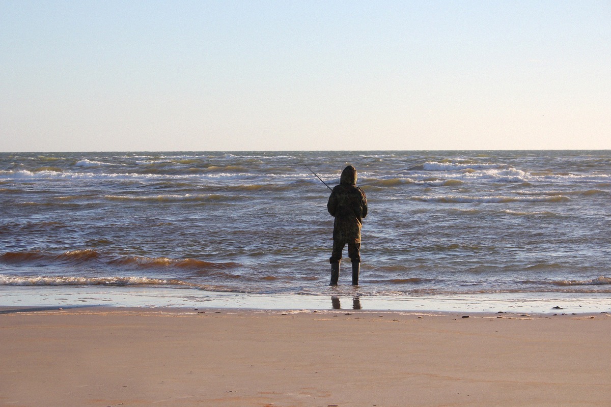 Angler in der Brandung am Sandstrand von Tornby bei Hirtshals